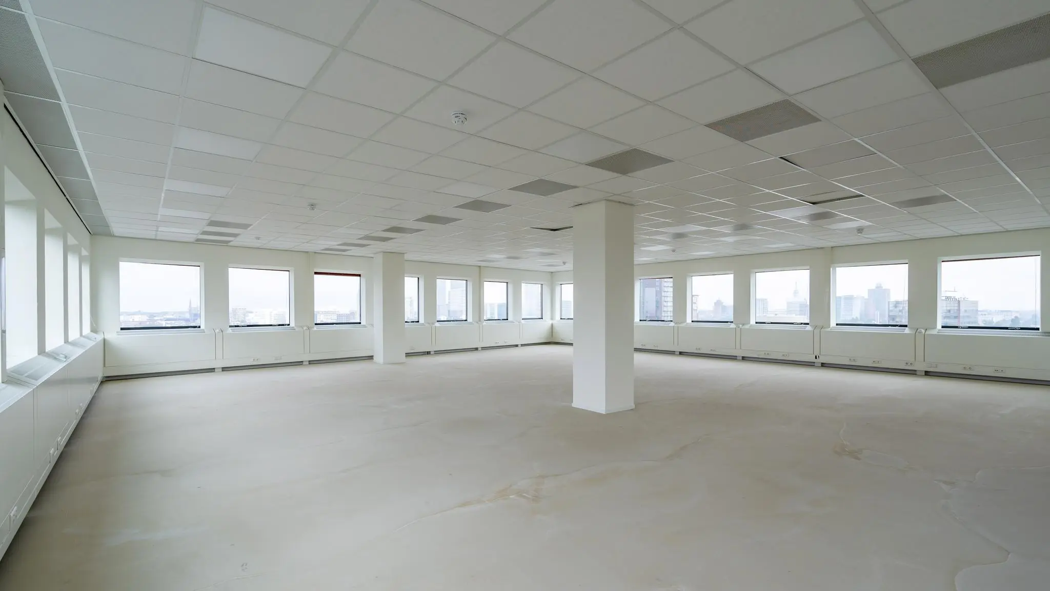 Leeg kantoorpand aan het Johanna Westerdijkplein met grote ramen en systeemplafond.